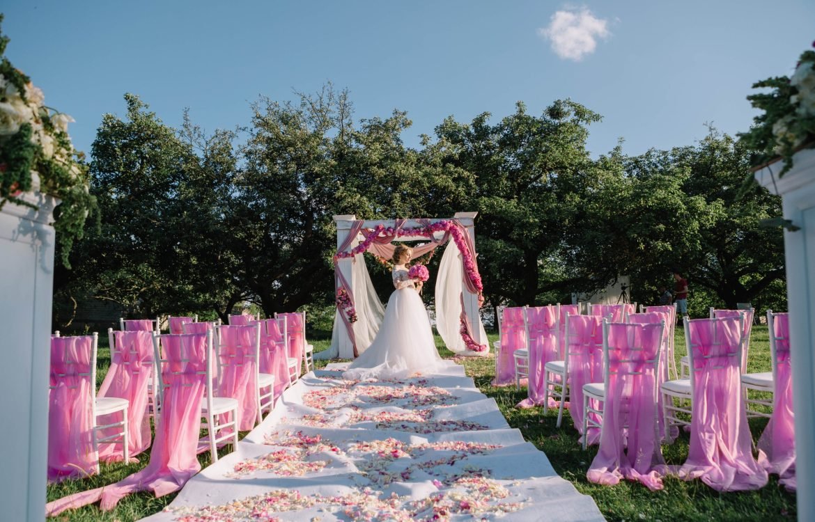 beautiful young bride standing near arch at the wedding ceremony